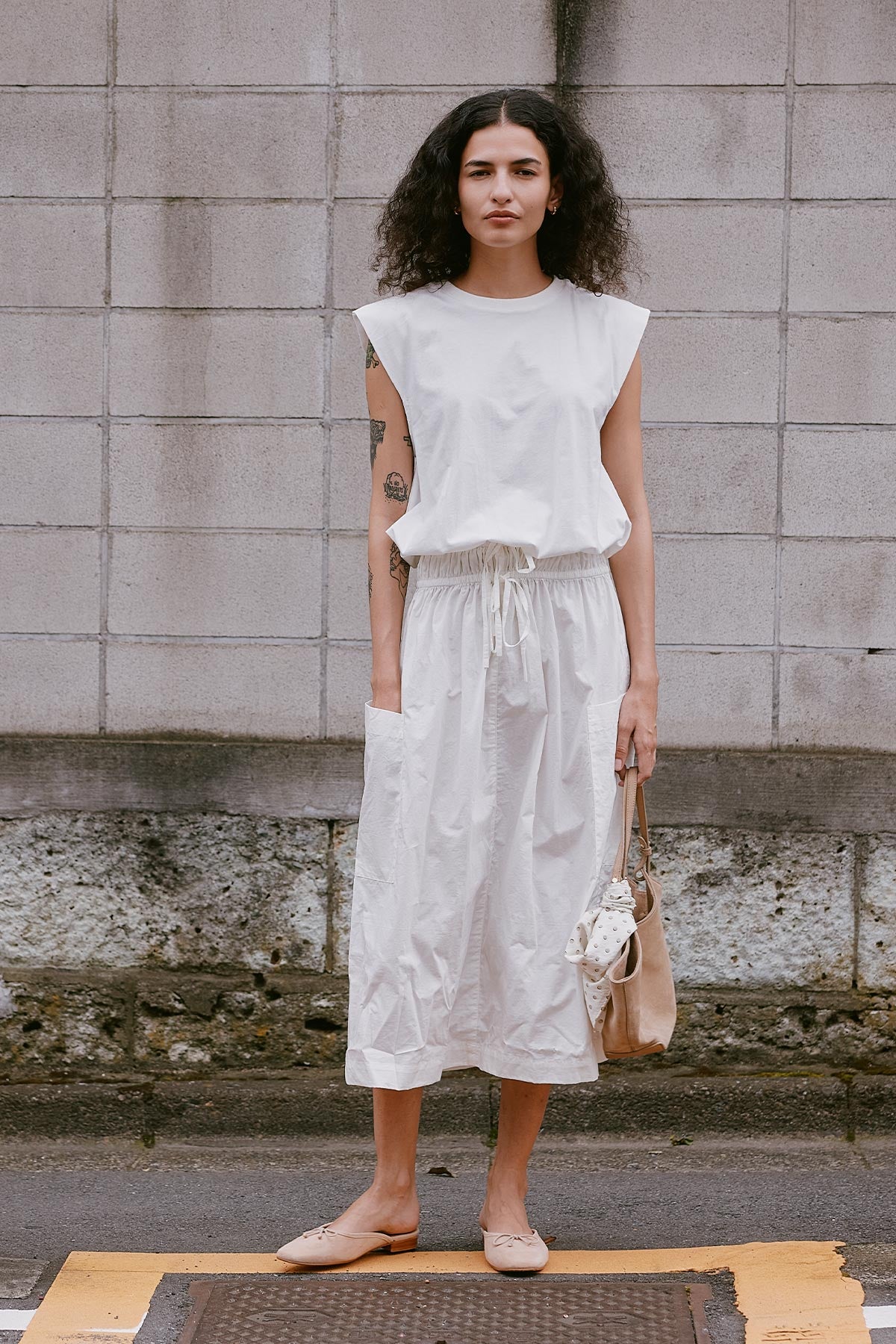 Model wearing a Jessica Organic Midi Dress in Tonal Bone by ROWIE the Label, lifestyle shot on a Tokyo street