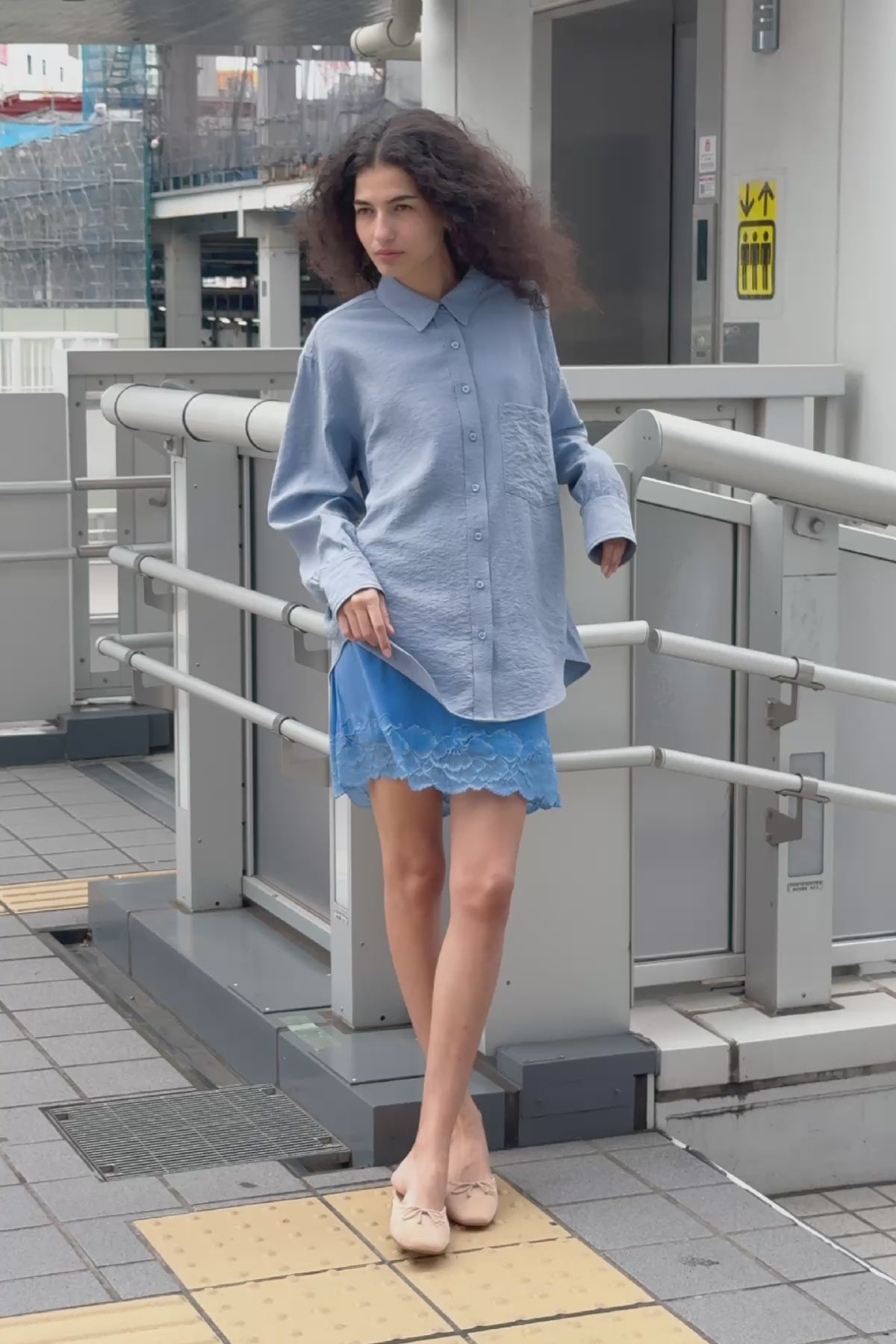 Video of model wearing a Ramona Silk Long Sleeve Shirt in Periwinkle, styled with the Jessica Cargo Mini Skirt in Washed Khaki by ROWIE the Label, filmed on a Tokyo street.