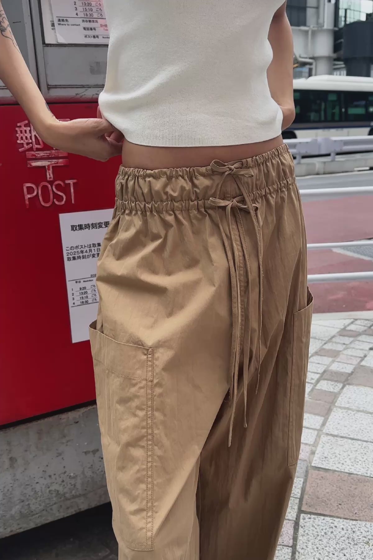 Video of model wearing a Blake Contrast Knit Tank top in cream with Ink blue trim, styled with the Jessica Cargo Pants in Washed Khaki by ROWIE the Label, on the streets of Tokyo.