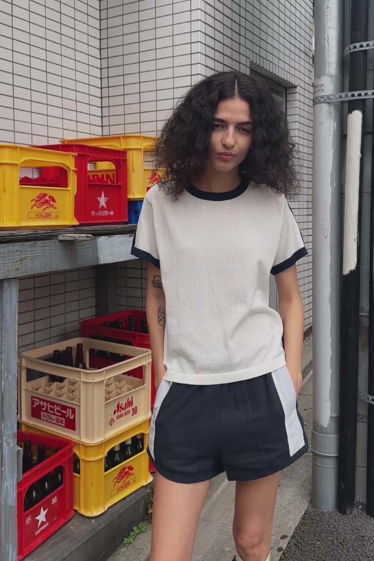 Video of model wearing Simone Linen Shorts in Ink, styled with the Rania Contrast Knit Tee in Ink by ROWIE the Label, filmed on a Tokyo street.