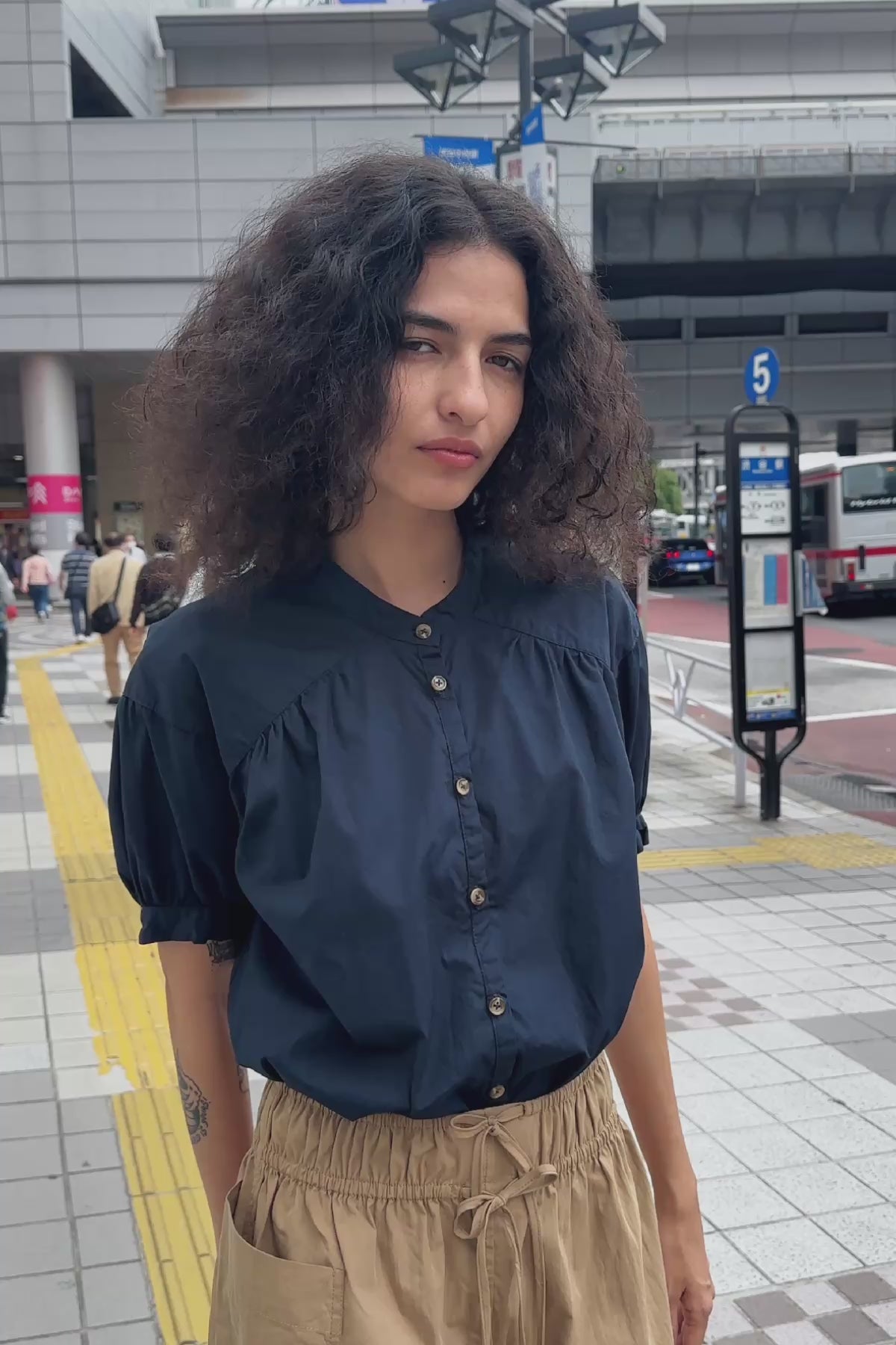 Video of model wearing a Jessica Cargo Mini Skirt in Washed Khaki, styled with the Cora Spring Blouse in Ink Cotton by ROWIE the Label, filmed on a city street in Tokyo.