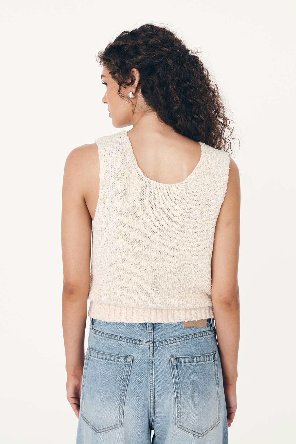 Back studio view of model wearing a Catalina Knit Tank in Creme, paired with the Percy Curve Seam Jeans in Faded Blue by ROWIE the Label.