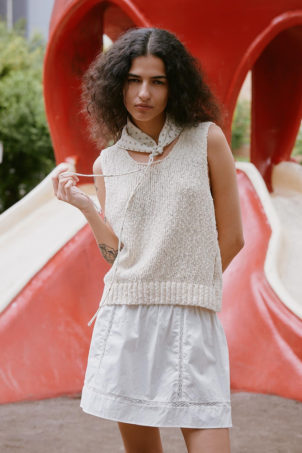 Model wearing a Catalina Knit Tank in Creme, paired with the Suri Lace Mini Skirt in Bone by ROWIE the Label, lifestyle shot outdoors.