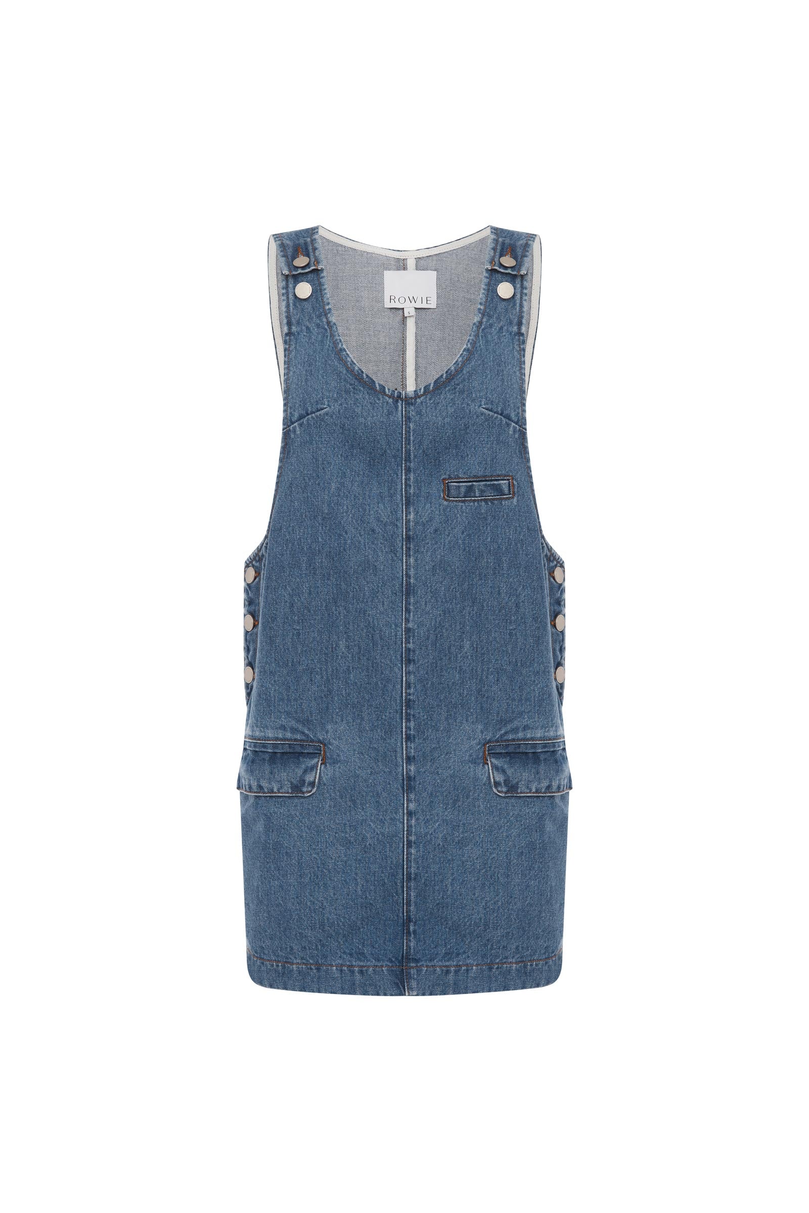 Blue denim pinafore mini dress with scoop neck and welt pockets on a white background