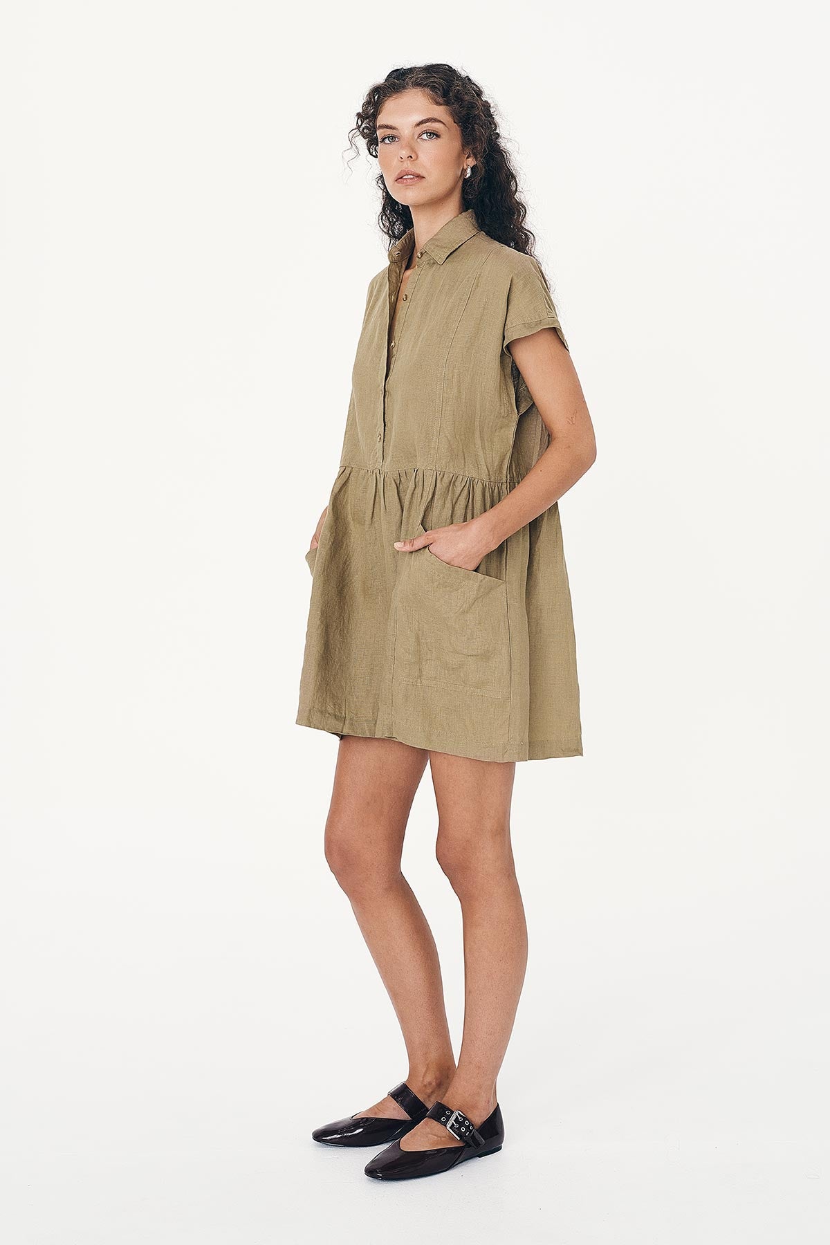 Side studio view of model wearing a Gina Linen Mini Dress in Dusty Olive by ROWIE the Label.