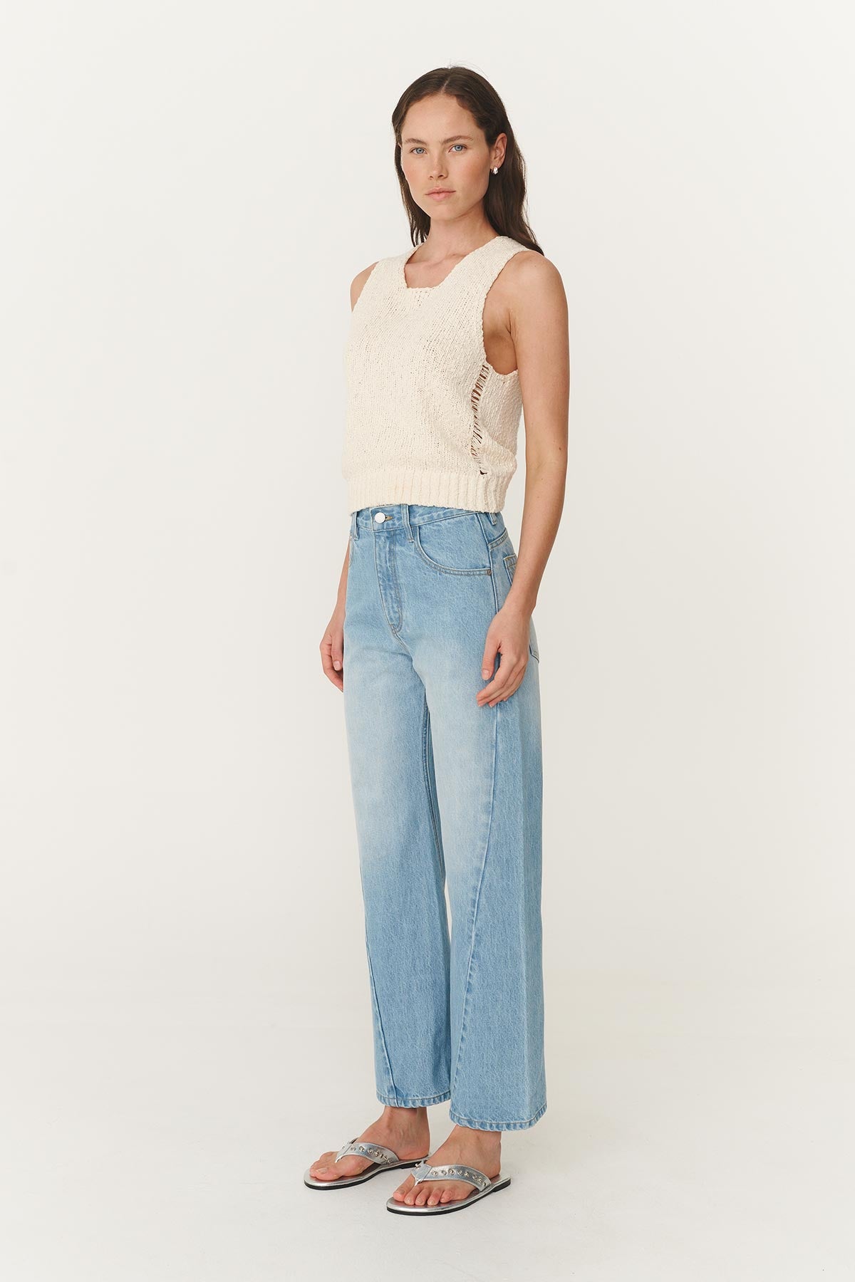 Angled side studio view of model wearing Percy Curve Seam Jeans in Faded Blue, styled with the Catalina Knit Tank in Creme by ROWIE the Label.