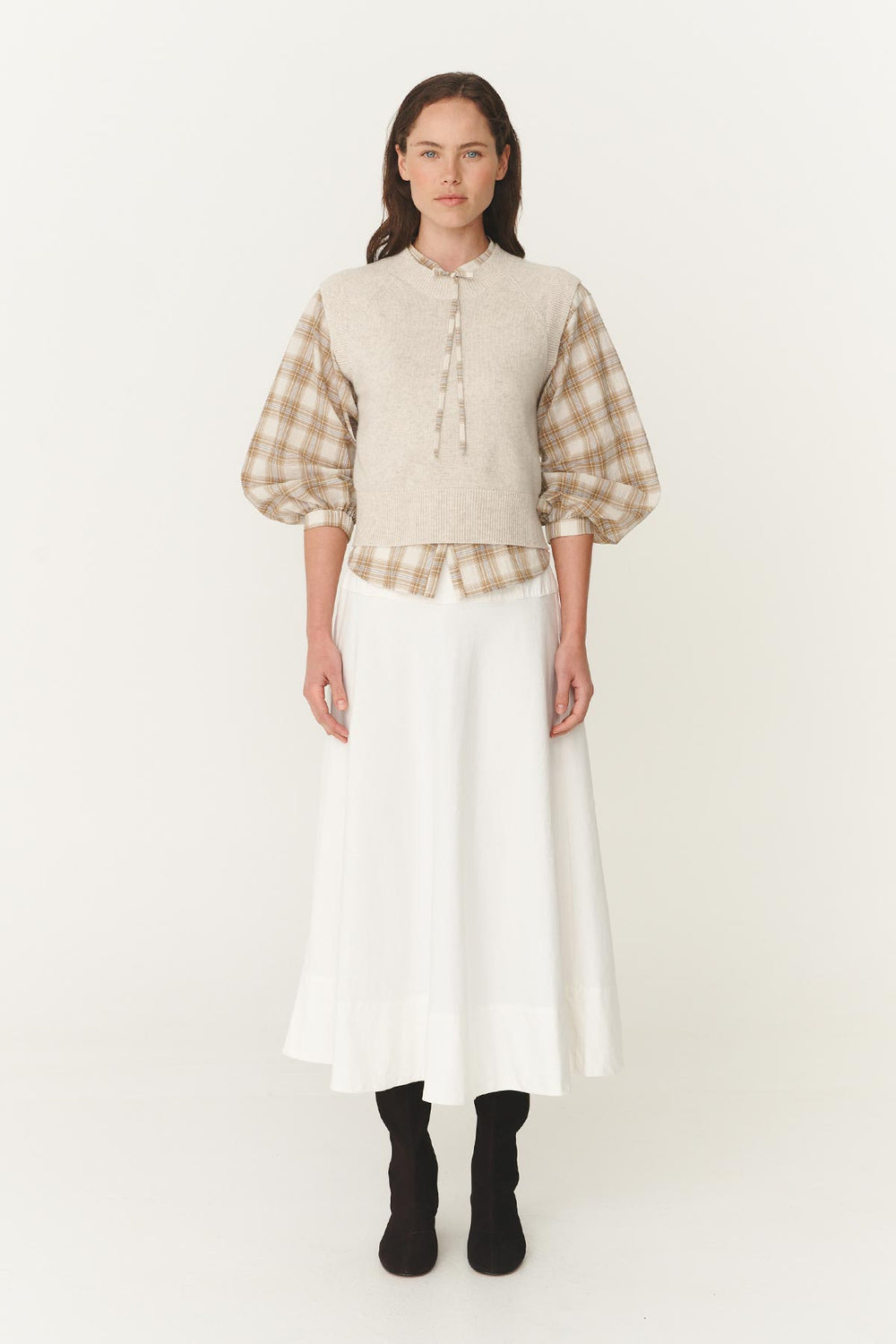 Stylish Autumn Winter Women's outfit featuring the Anouk Midi Skirt in White, Eden Knee high boots in dark Brown Suede, a light sculpted paid shirt and creme cashmere knit vest