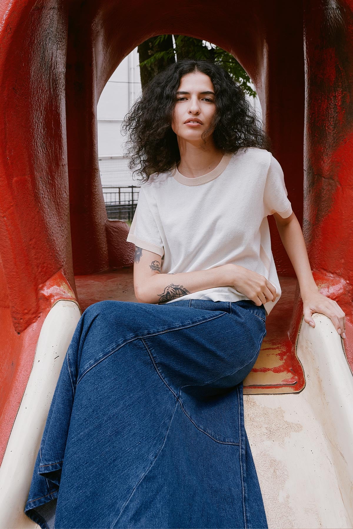 Model wearing a Rania Contrast Knit Tee in Oat Milk, styled with the Vashti Denim Midi Skirt in Classic Denim by ROWIE the Label, lifestyle shot in Tokyo.