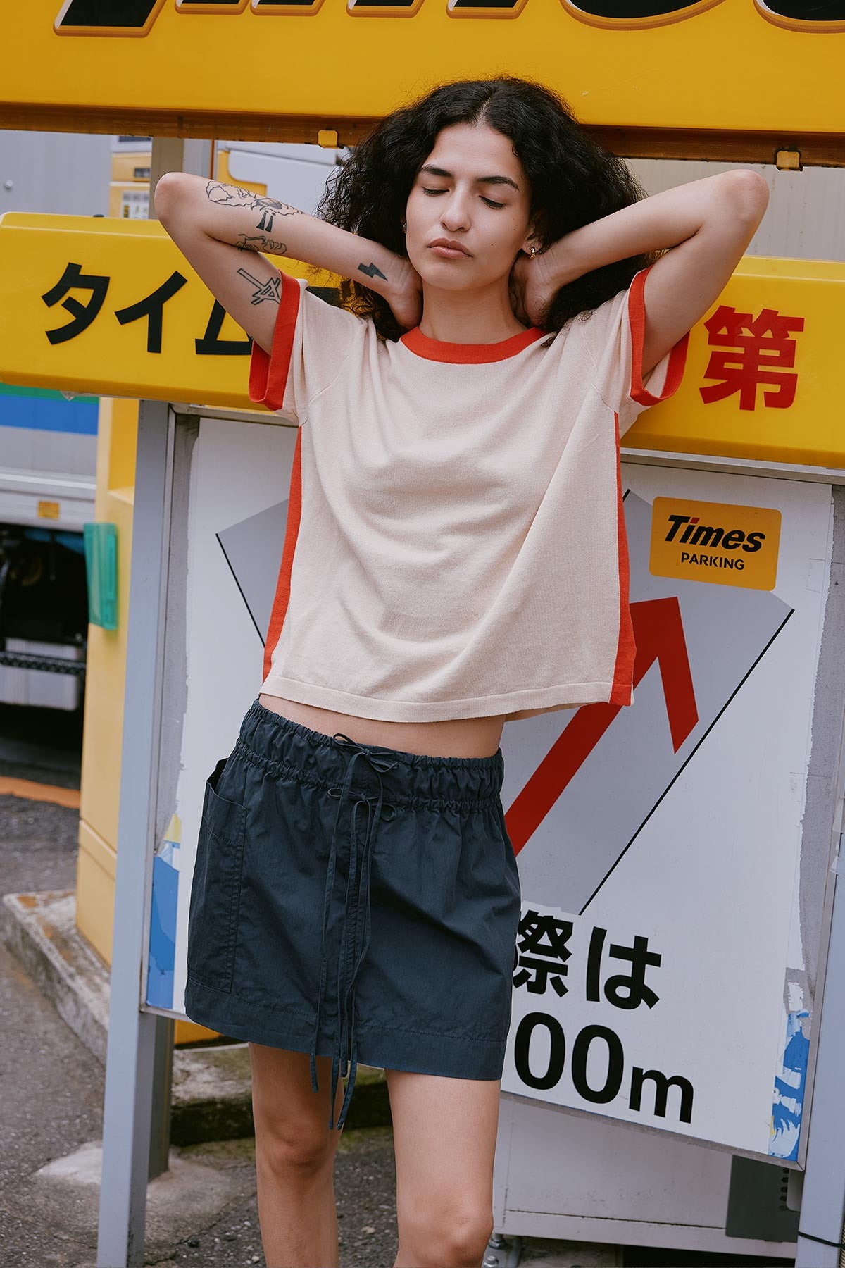 Women wears ROWIE The Label Rania Contrast Tee in Spiced Latte, made from 100% Superfine Cotton Zero Waste Knit paired with the Jessica Cargo Mini Skirt Washed Ink