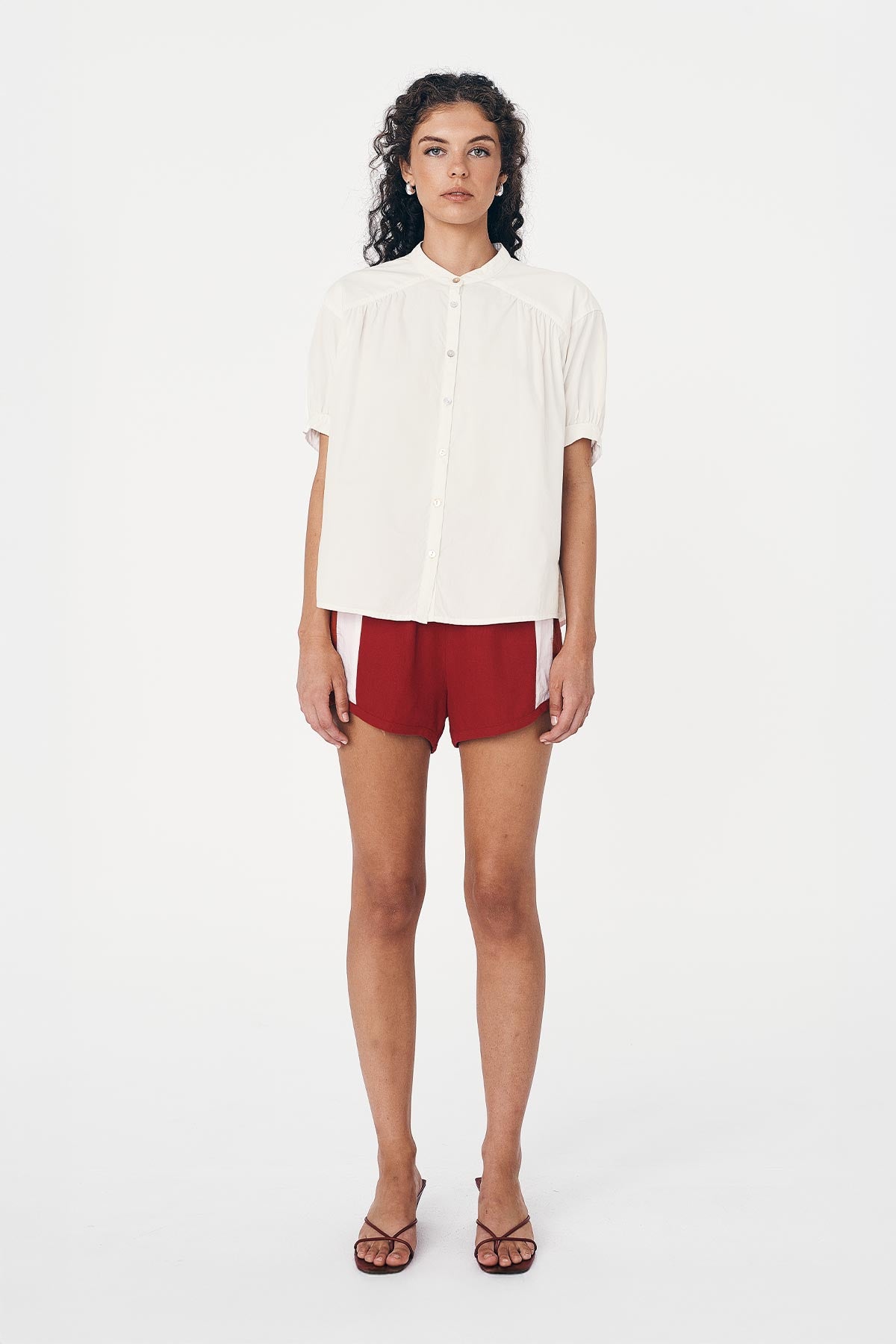 Woman wearing a White Print Blouse and Siren Red Linen Shorts by ROWIE The Label