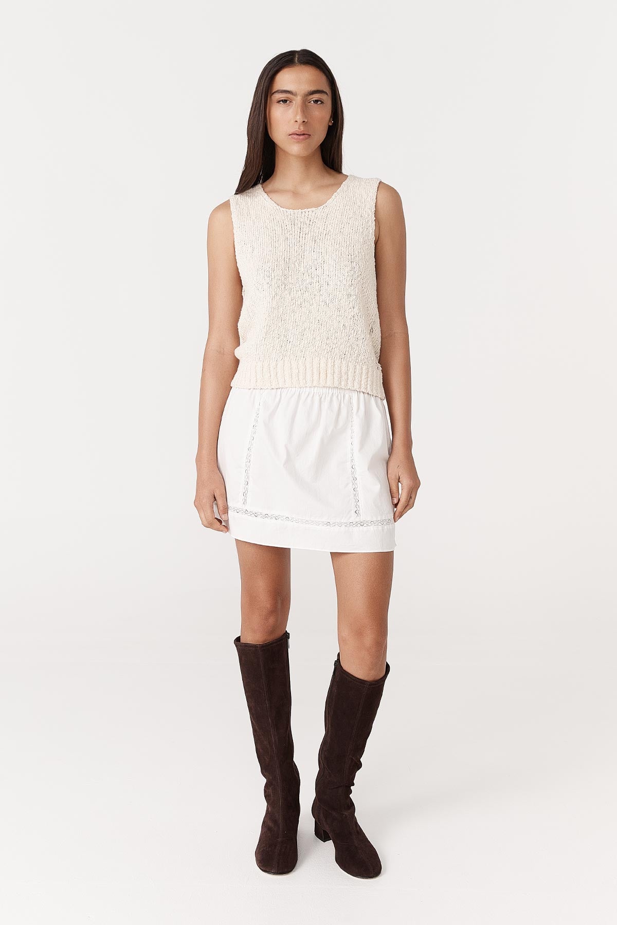 Model wearing a Suri Lace Mini Skirt in Bone, paired with the Catalina Knit Tank in Creme by ROWIE the Label, front studio view.