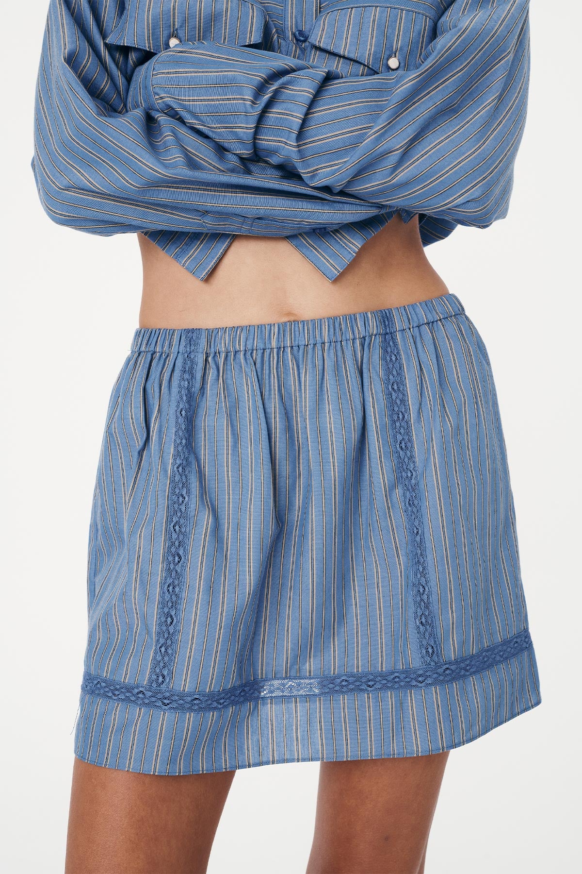 Front detail studio view of a Suri Lace Mini Skirt in Lagoon, styled with the Cole Stripe Crop Shirt in Lagoon by ROWIE the Label.